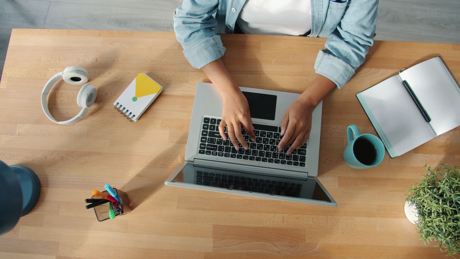 Vista cenital de un escritorio con un portátil y material de trabajo
