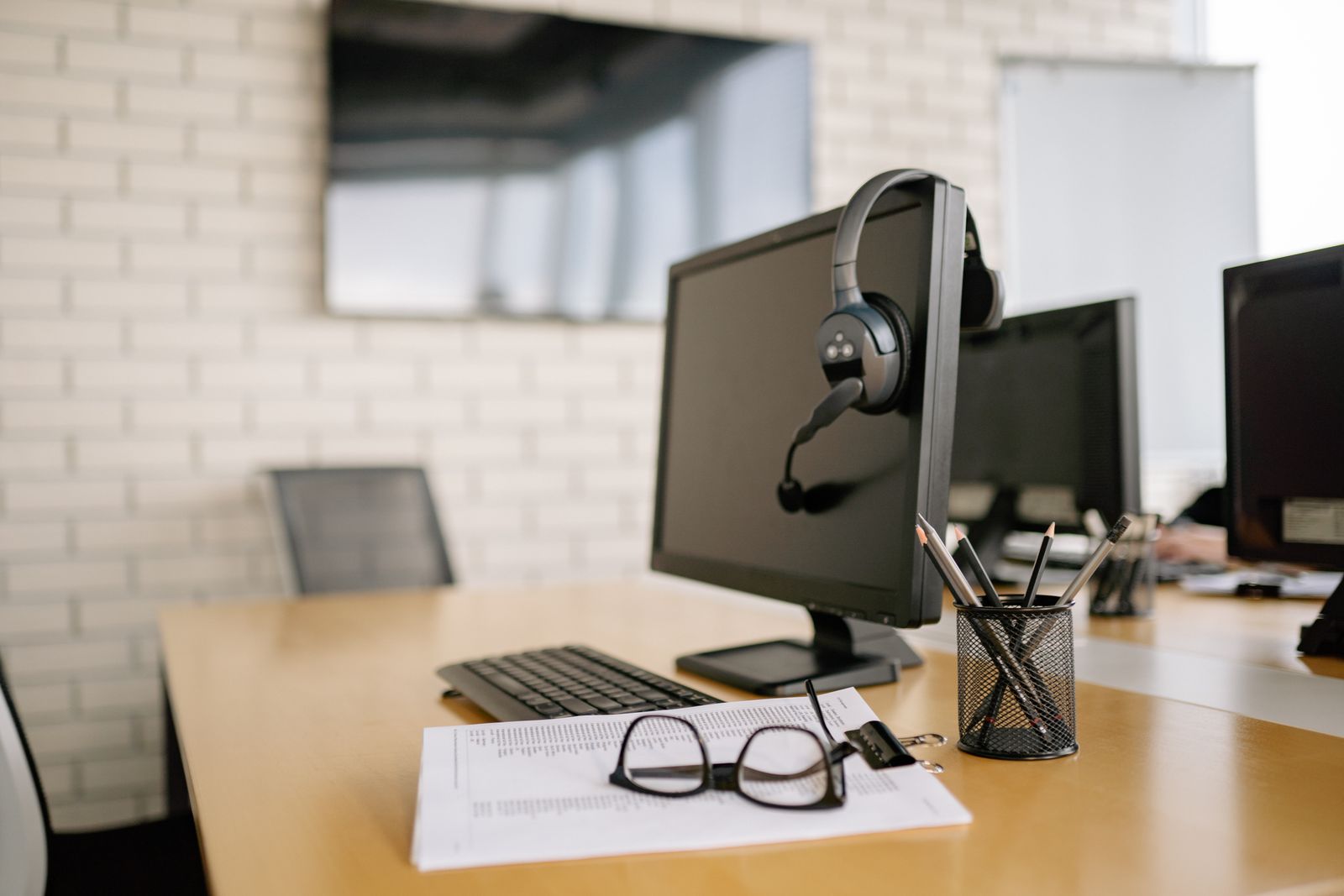 Auriculares con micrófono junto a un monitor en un espacio de atención